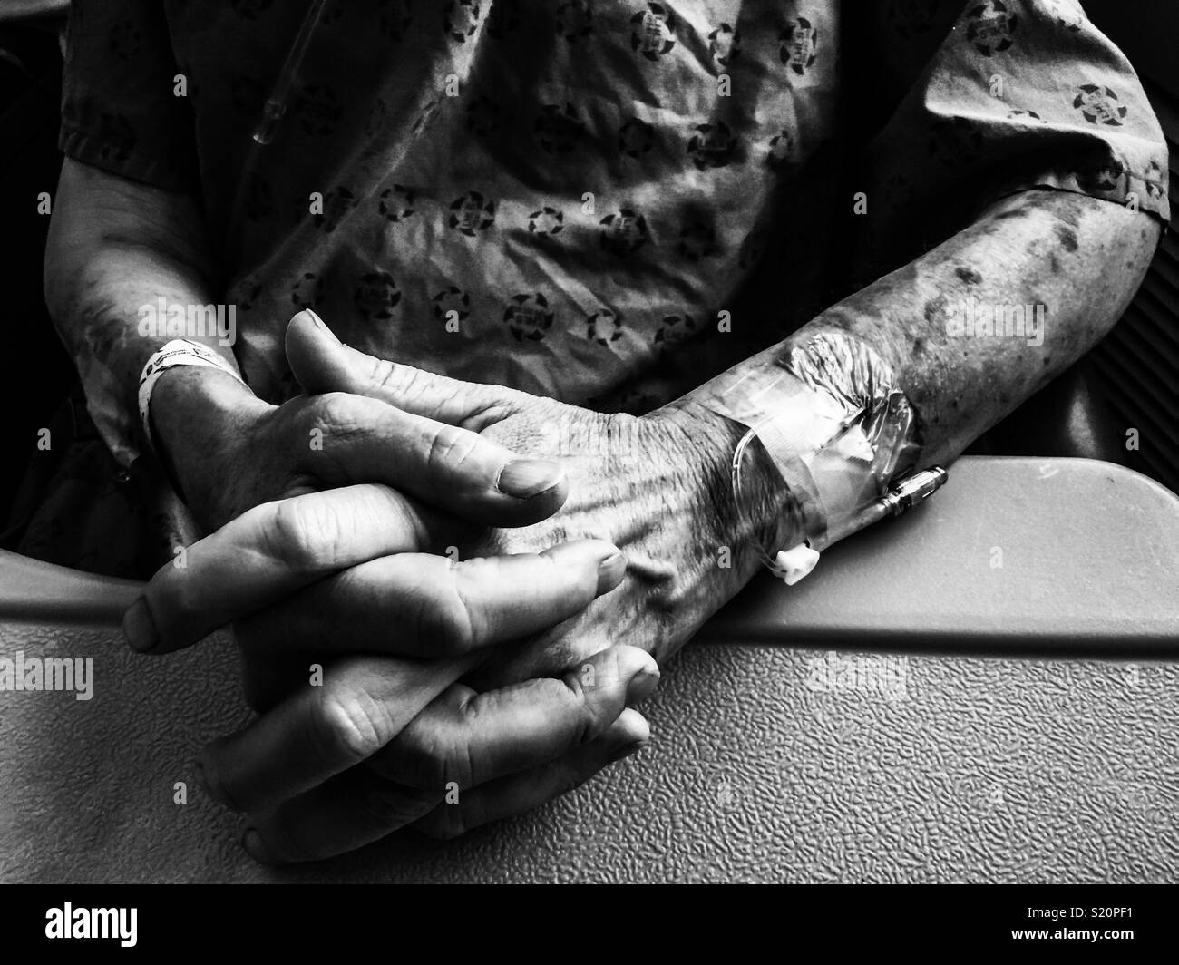 Fingers crossed. A man with multiple IVs and lesions - Smartphone Captured Stock Image