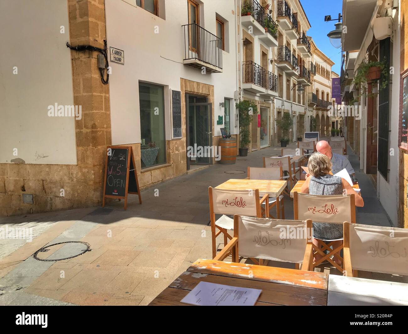 Street scene with couple at outdoor cafe, in the Old Town area of Javea / Xabia on the Costa Blanca, Spain Stock Photo