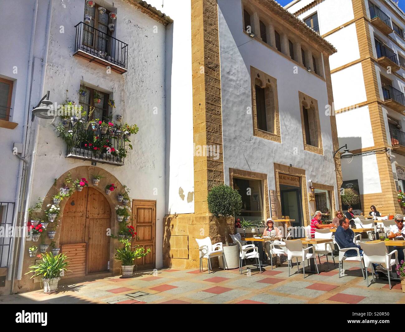 Street scene with people at outdoor cafe, in the Old Town area of Javea / Xabia on the Costa Blanca, Spain - Smartphone Captured Stock Image
