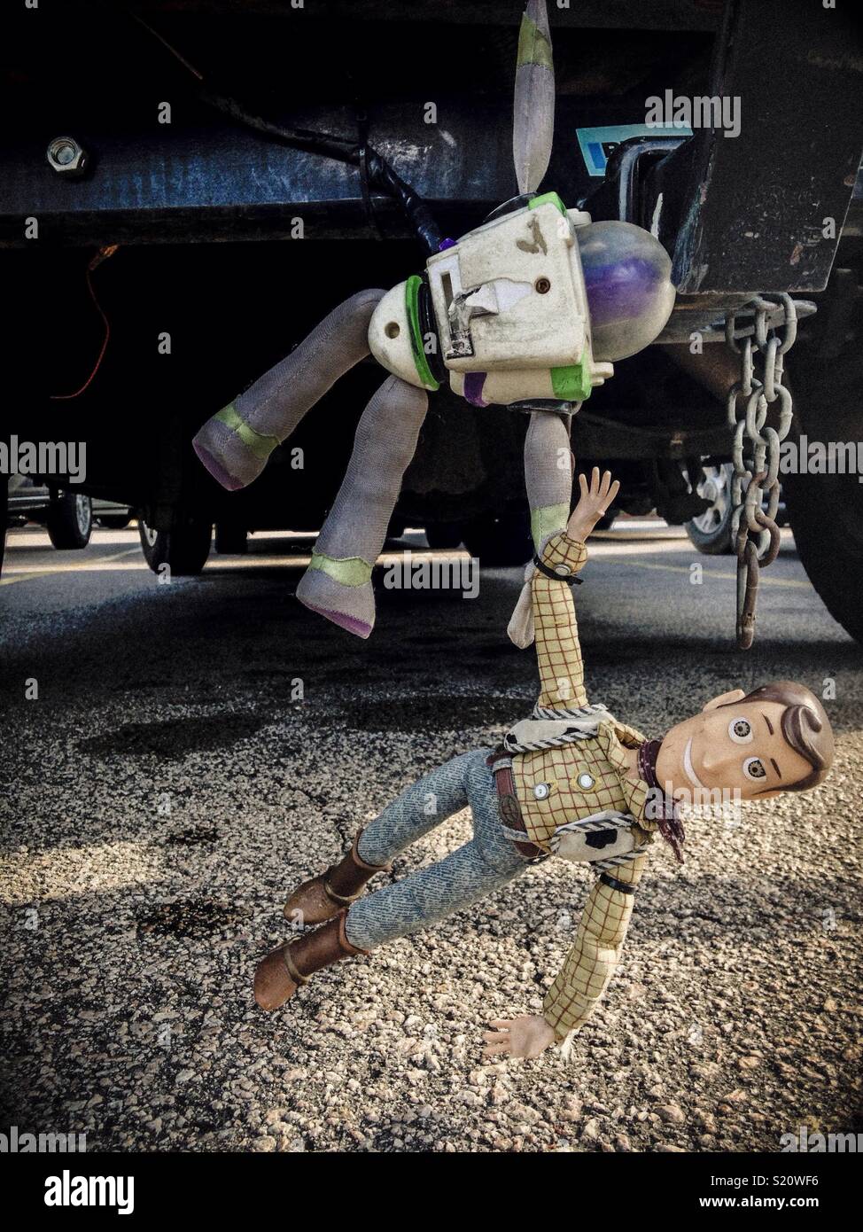Buzz Lightyear and Woody toys clinging to bumper of vehicle in North Carolina parking lot Stock Photo