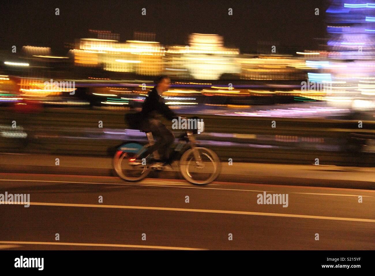 Slow shutter photo of cyclist at night Stock Photo