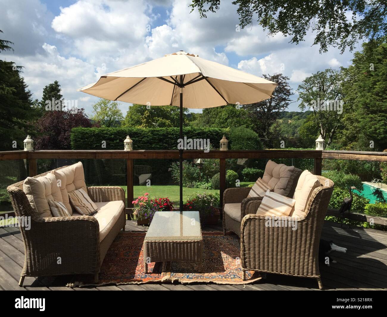 Sunny decking with parasol, seating and garden view Stock Photo