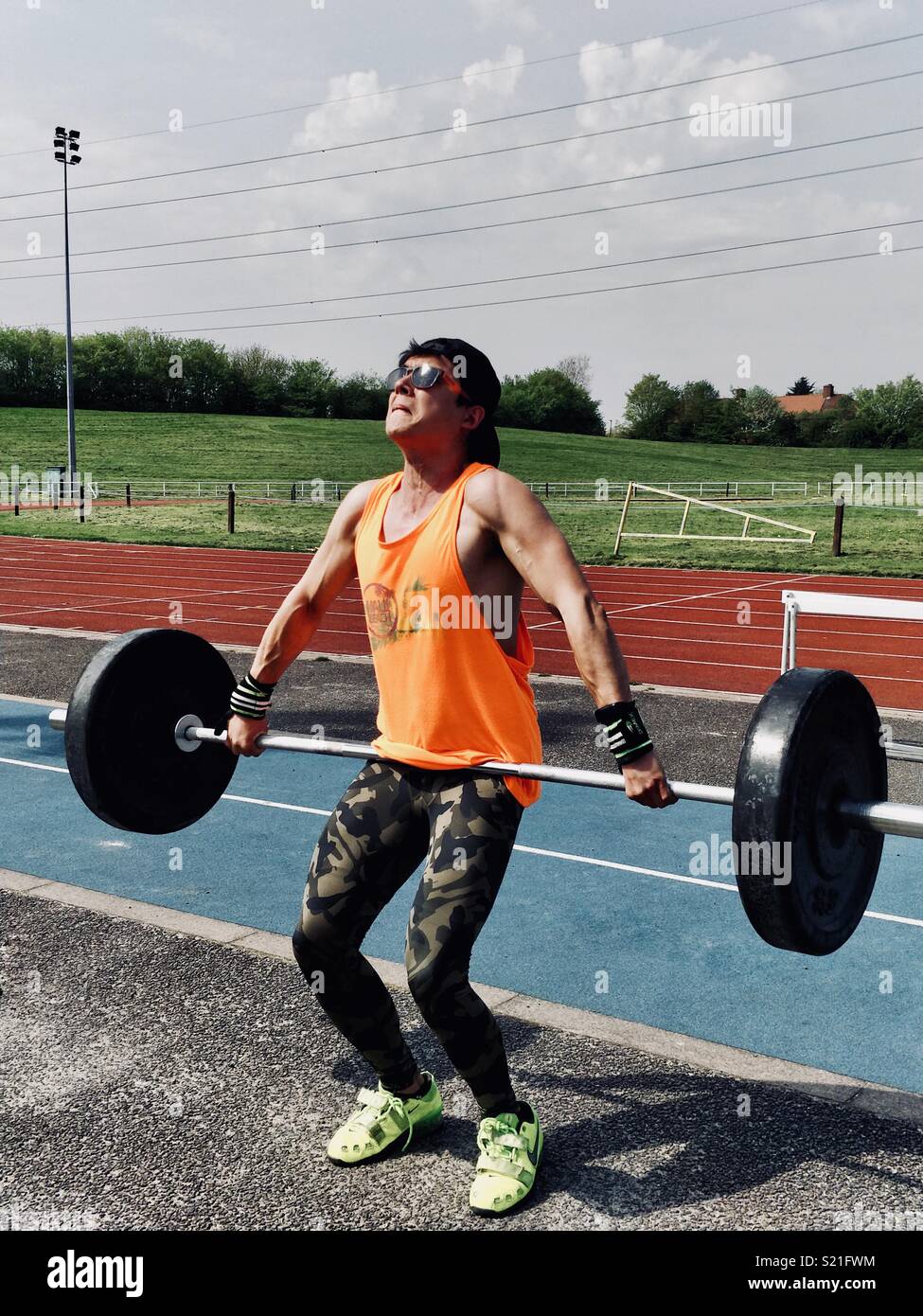 Olympic Weightlifter performing a snatch on a sunny day. Stock Photo