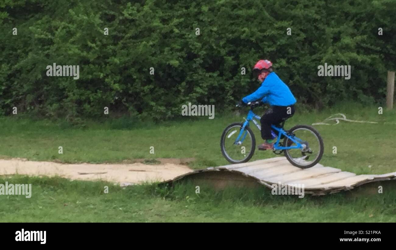 Boy on bike in blue jacket and red helmet Stock Photo