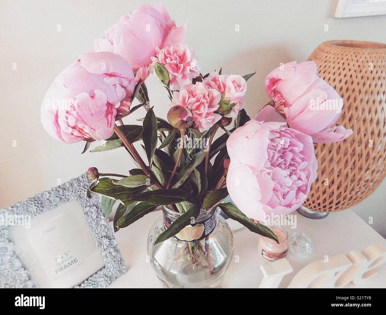 Pink peonies in a vase of water Stock Photo