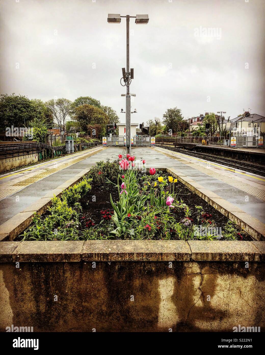 Grey yet colourful. A suburban London tube station where the gardening has not gone unnoticed. Stock Photo