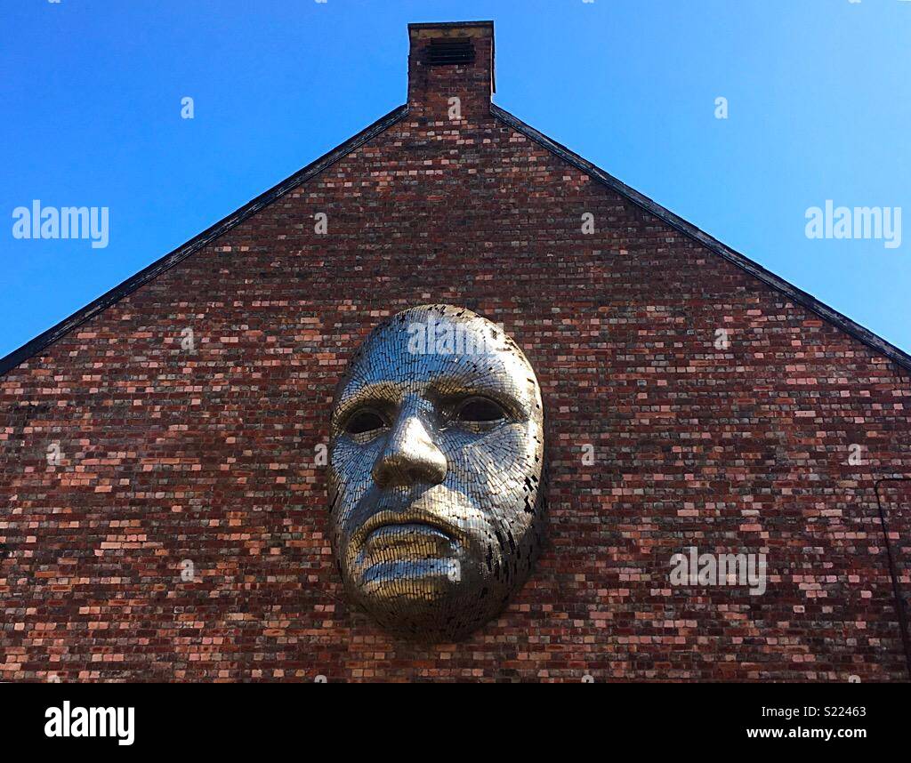 Metal face sculpture by Rick Kirby on the exterior wall of Lincoln
