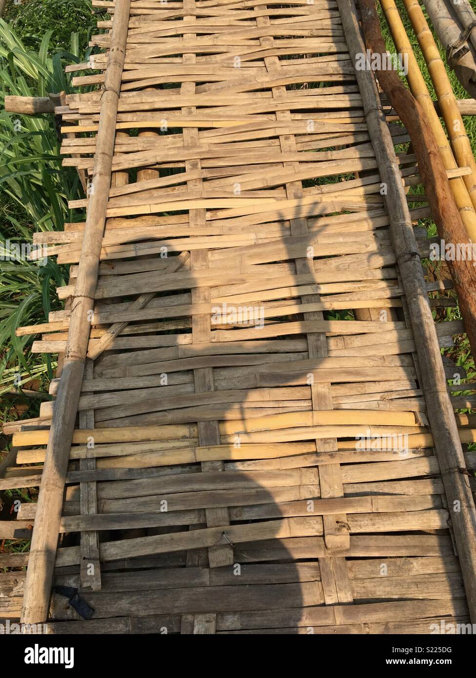 Shadow waving crossing a bamboo bridge In Laos - Smartphone Captured Stock Image