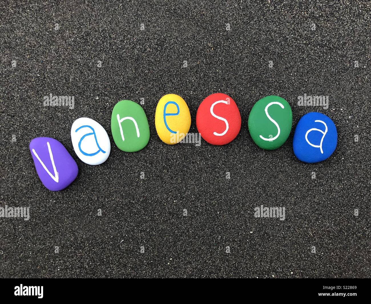 Vanessa, feminine given name with multicolored stones over black volcanic sand Stock Photo