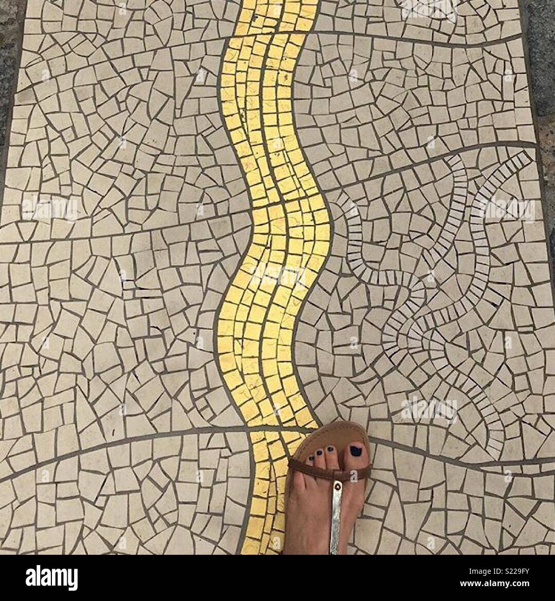 Foot on tile mosaic floor Stock Photo