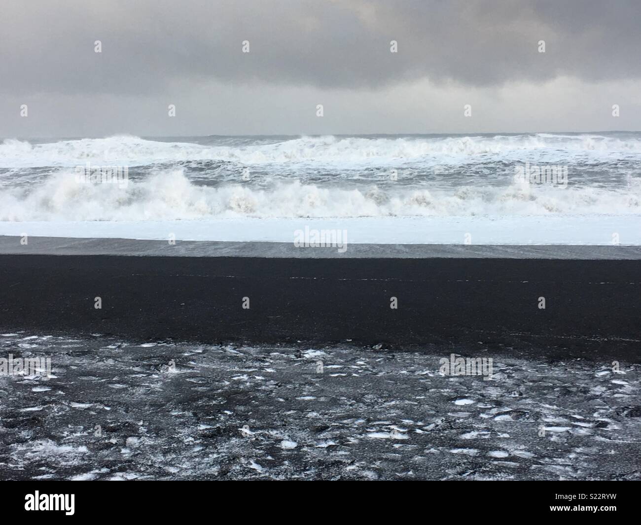 Iceland- land of ice and fire. Snow on black sand during a tempestuous storm. Stock Photo