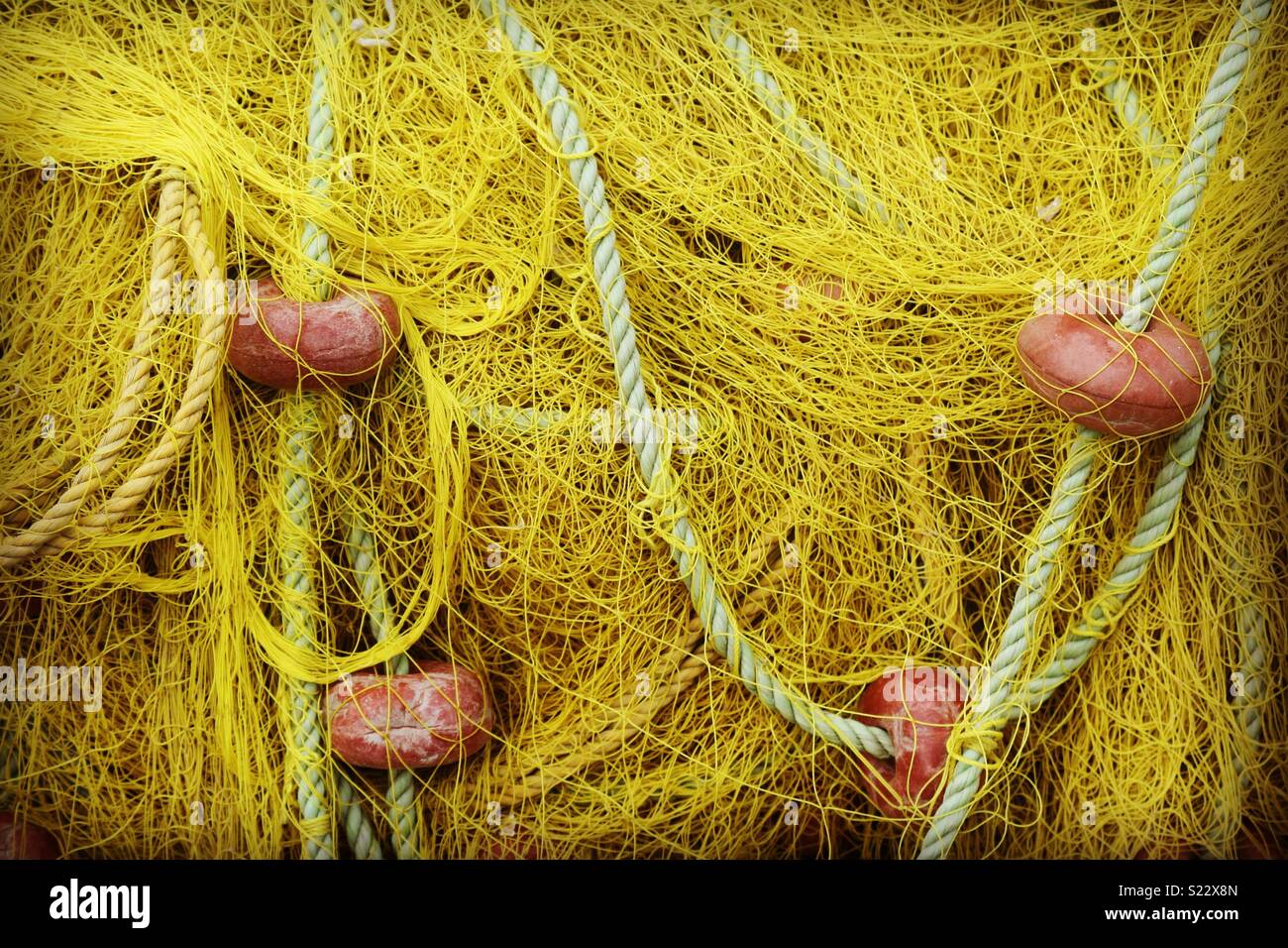 Closeup of a yellow fishing net with buoys - Smartphone Captured Stock Image
