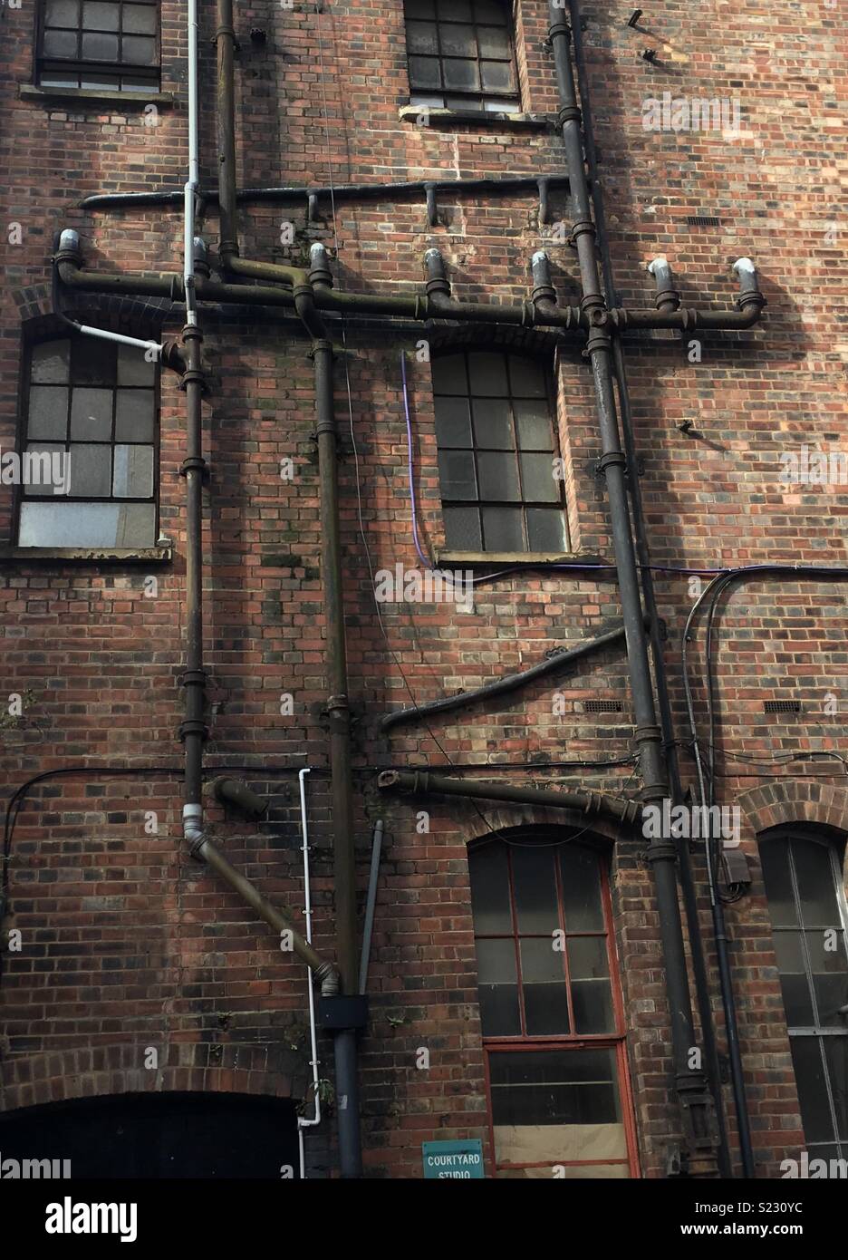Rear of old building with pipes Stock Photo Alamy