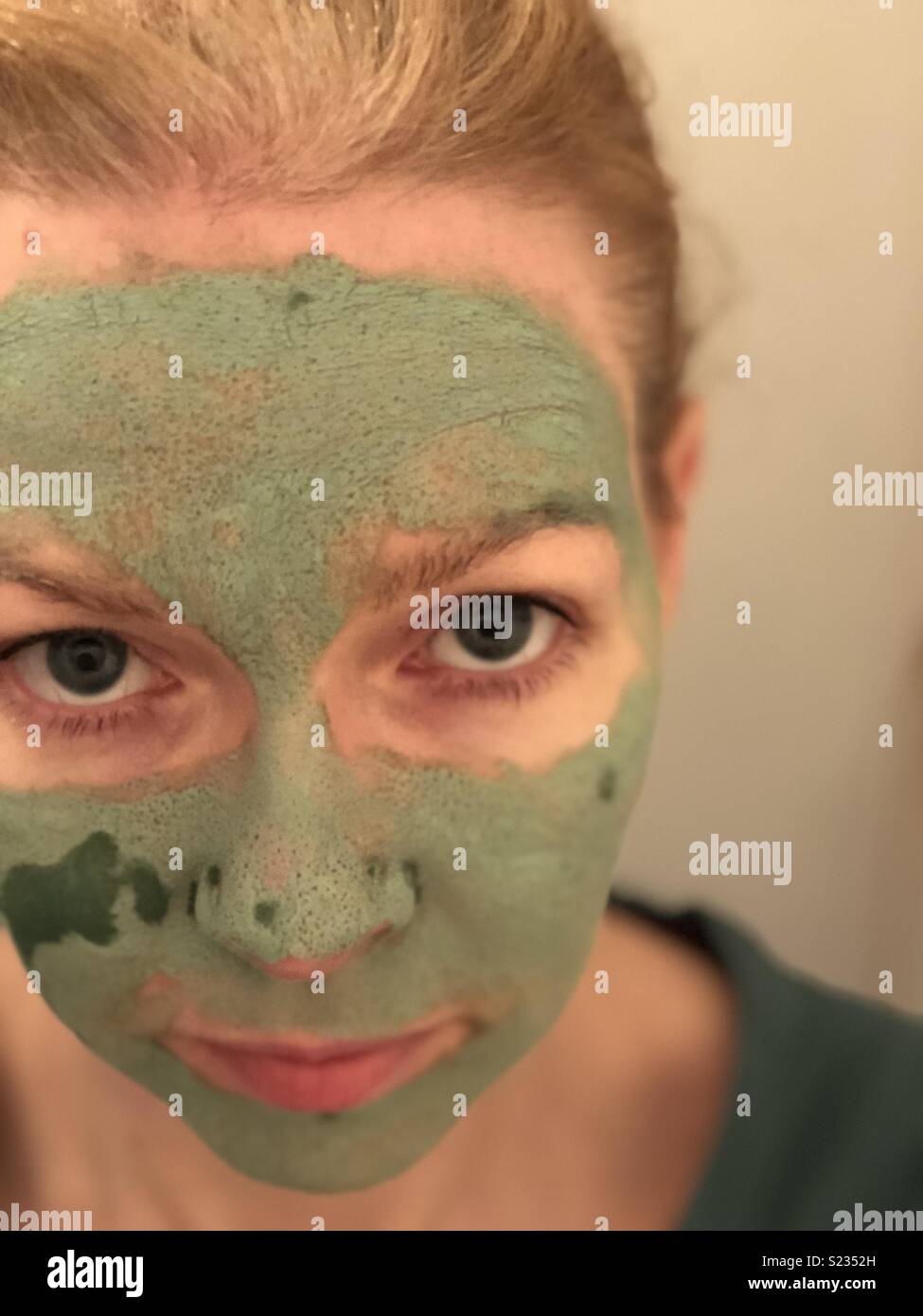 Woman wearing a green clay mask Stock Photo