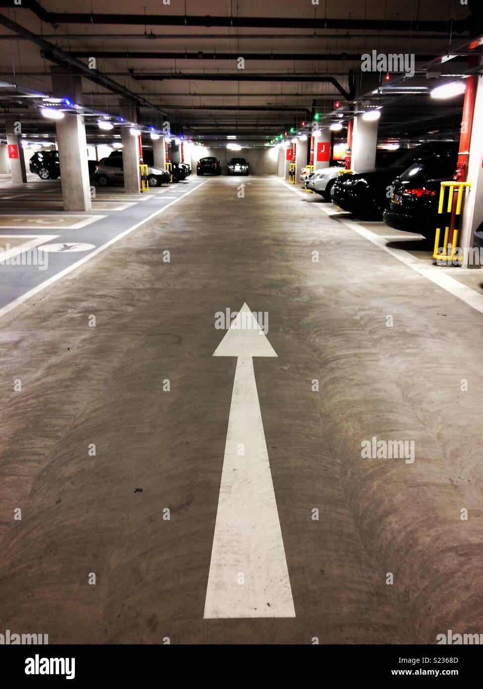 A white arrow pointing the way in an underground car park - Smartphone Captured Stock Image