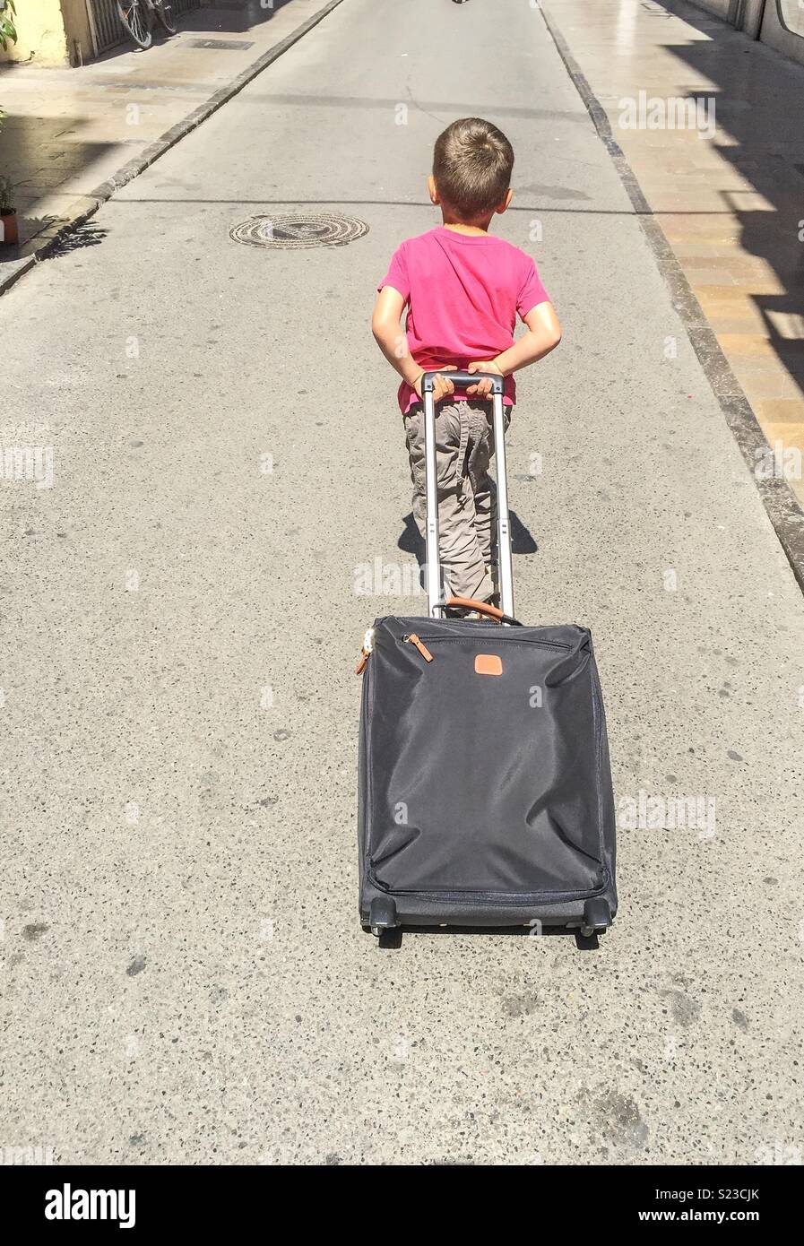 Kid carrying a suitcase - Smartphone Captured Stock Image