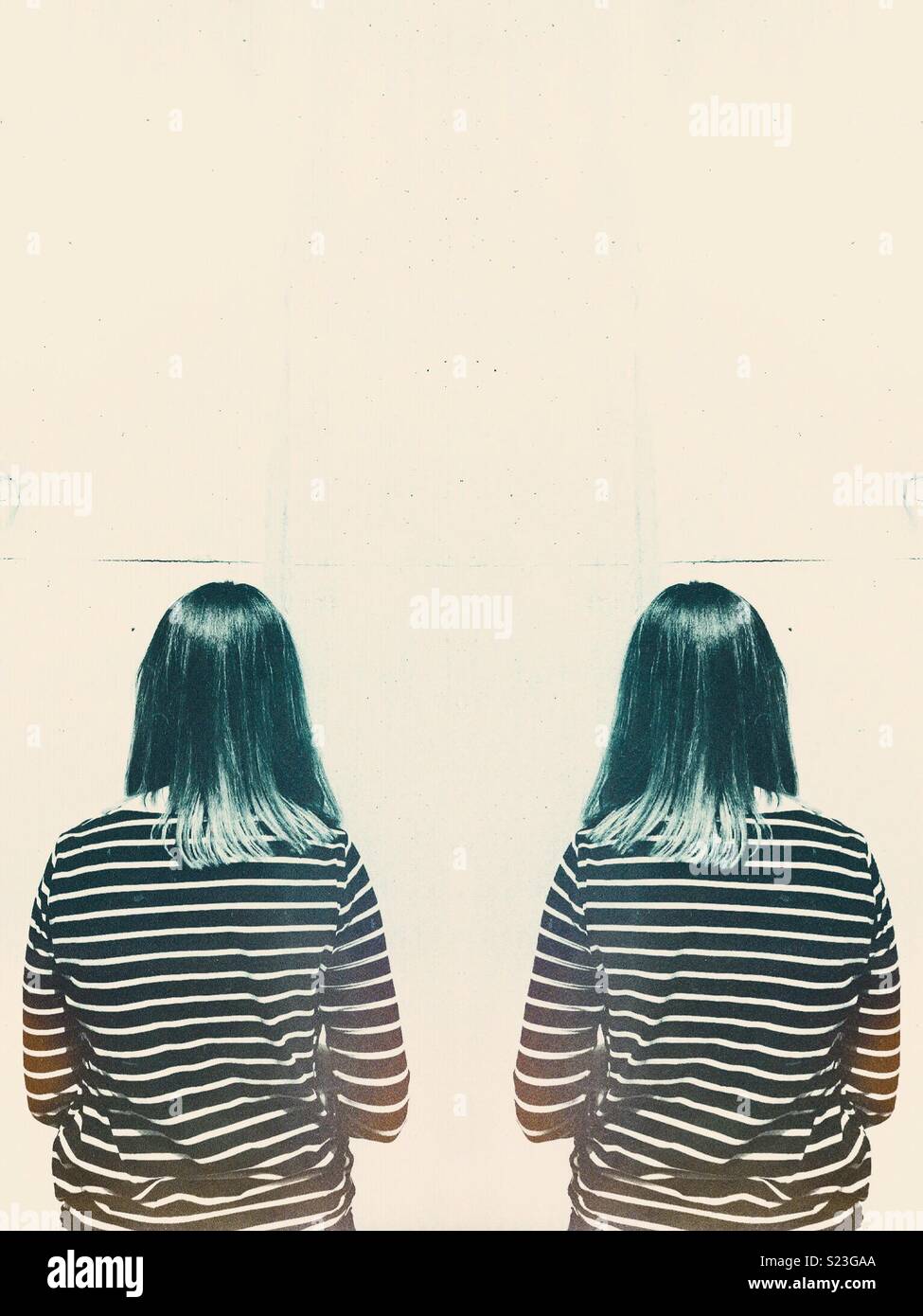 Symmetrical image of a young woman facing a wall - Smartphone Captured Stock Image