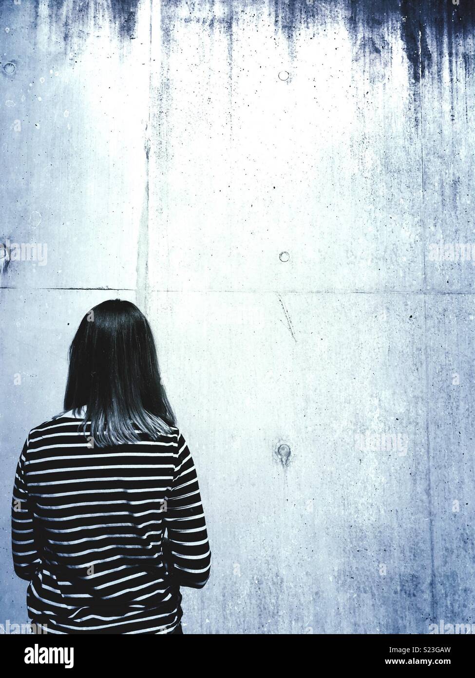 Single young woman looking at a wall - Smartphone Captured Stock Image