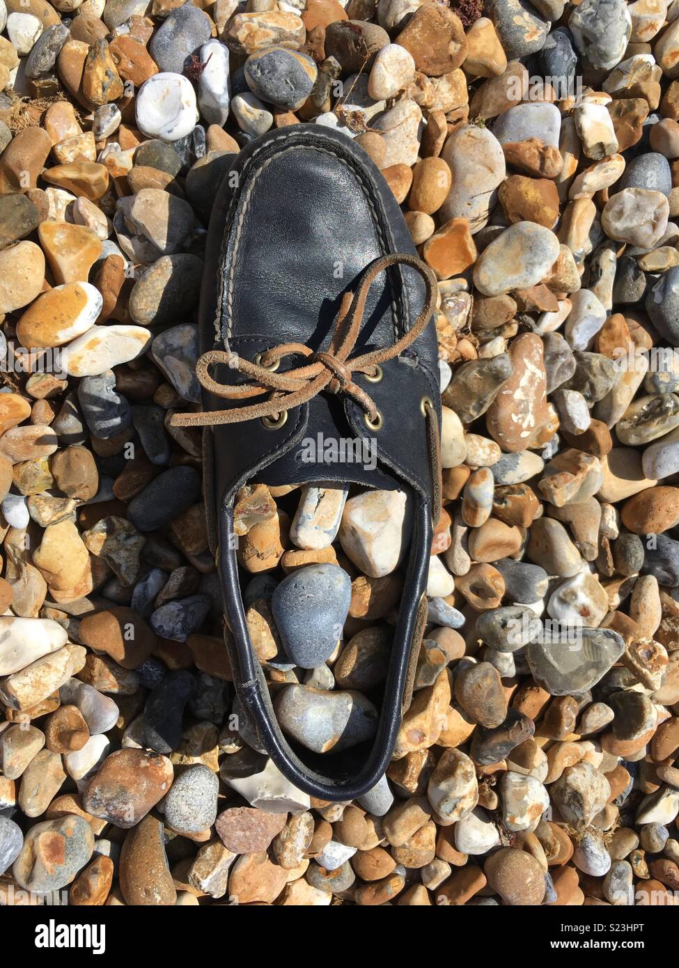 Deck shoe on a pebble beach Stock Photo Alamy
