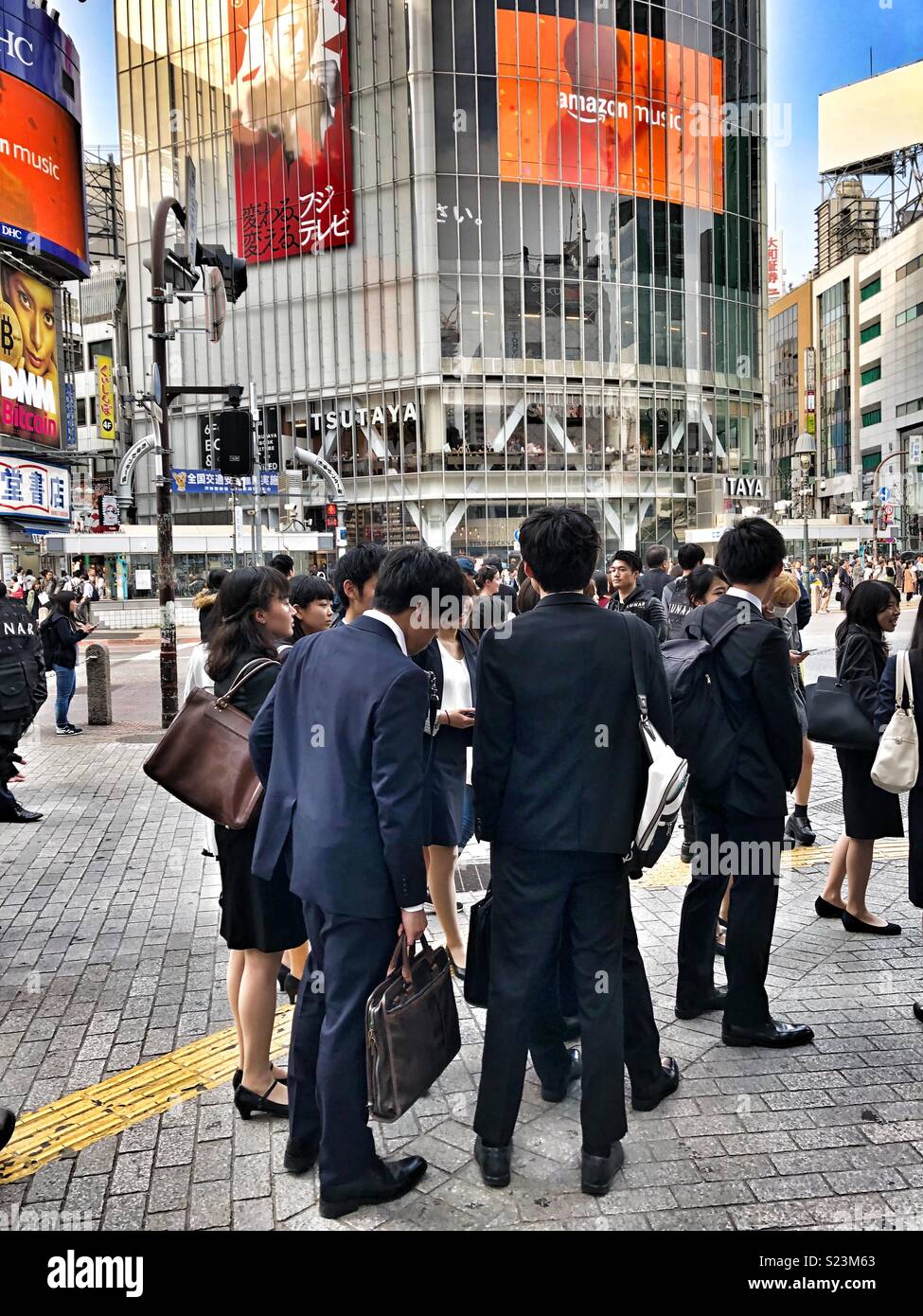 Young business men and women standing on a Tokyo street corner. - Smartphone Captured Stock Image