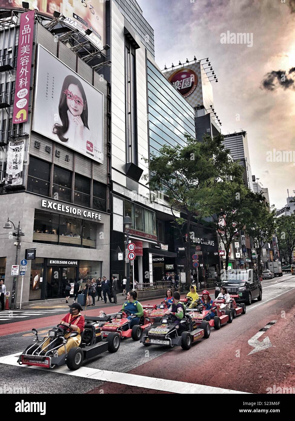 Tourists dressed in superhero outfits driving around Tokyo in go carts. - Smartphone Captured Stock Image