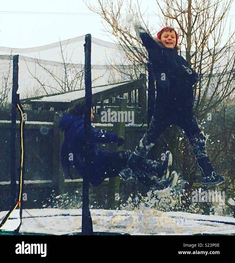 Kids playing on trampoline in snow Stock Photo Alamy
