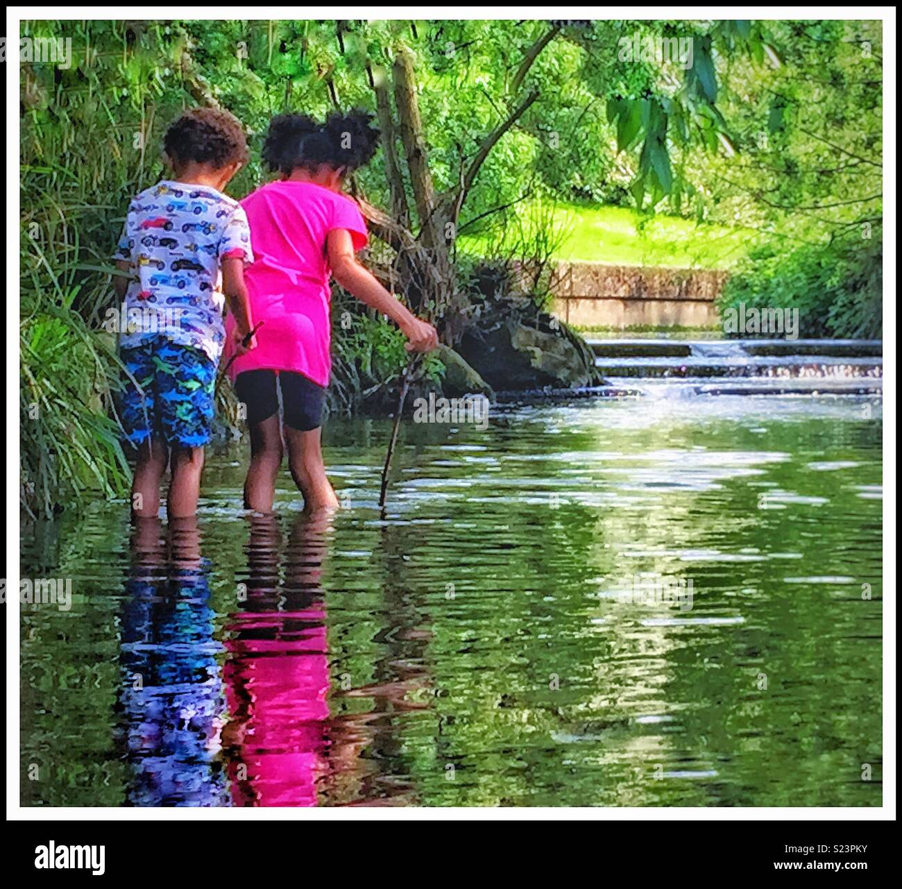 Two children paddling in a stream Stock Photo Alamy