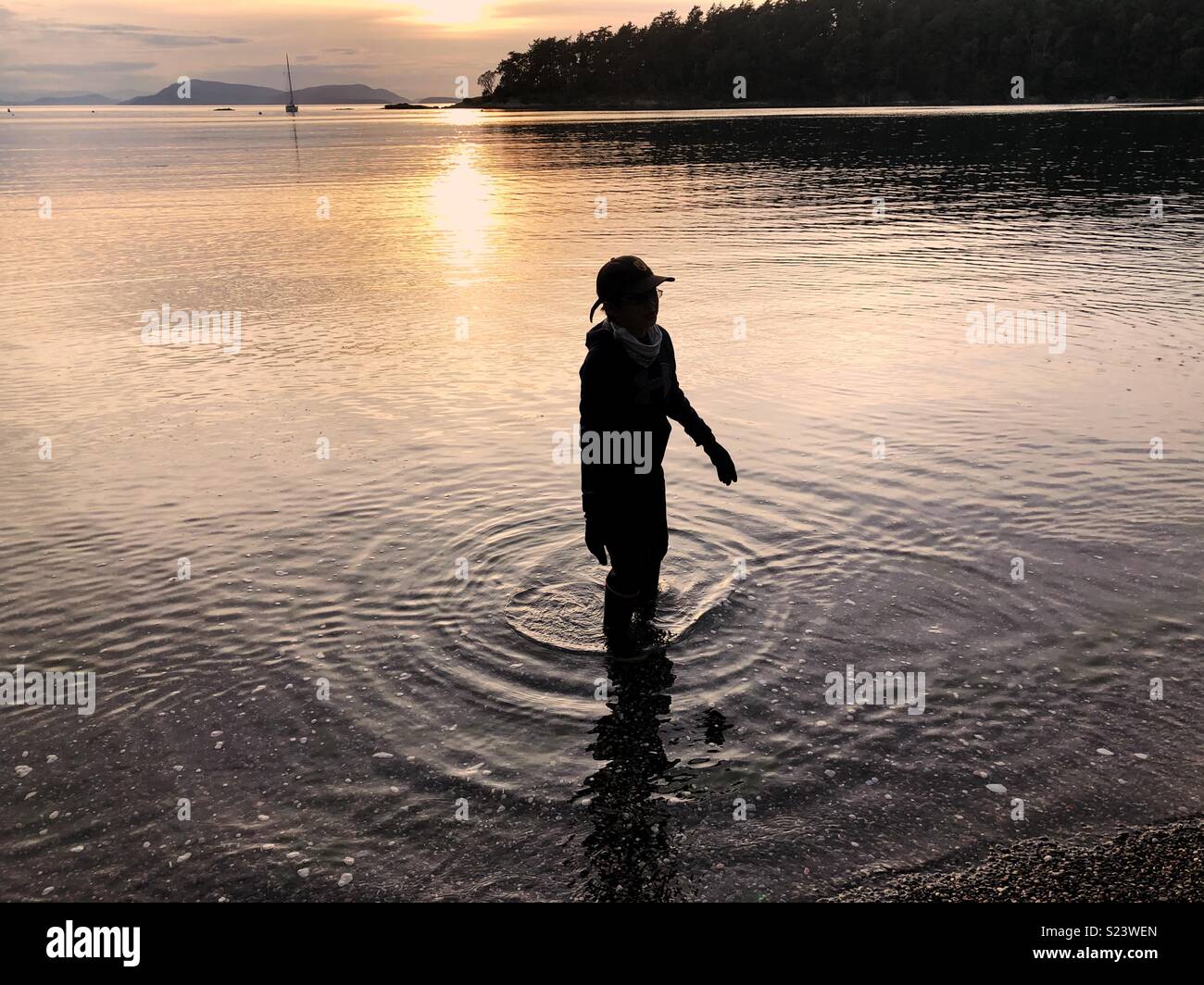 Boy in the water at sunset on Sucia Island, part of San Juan ...