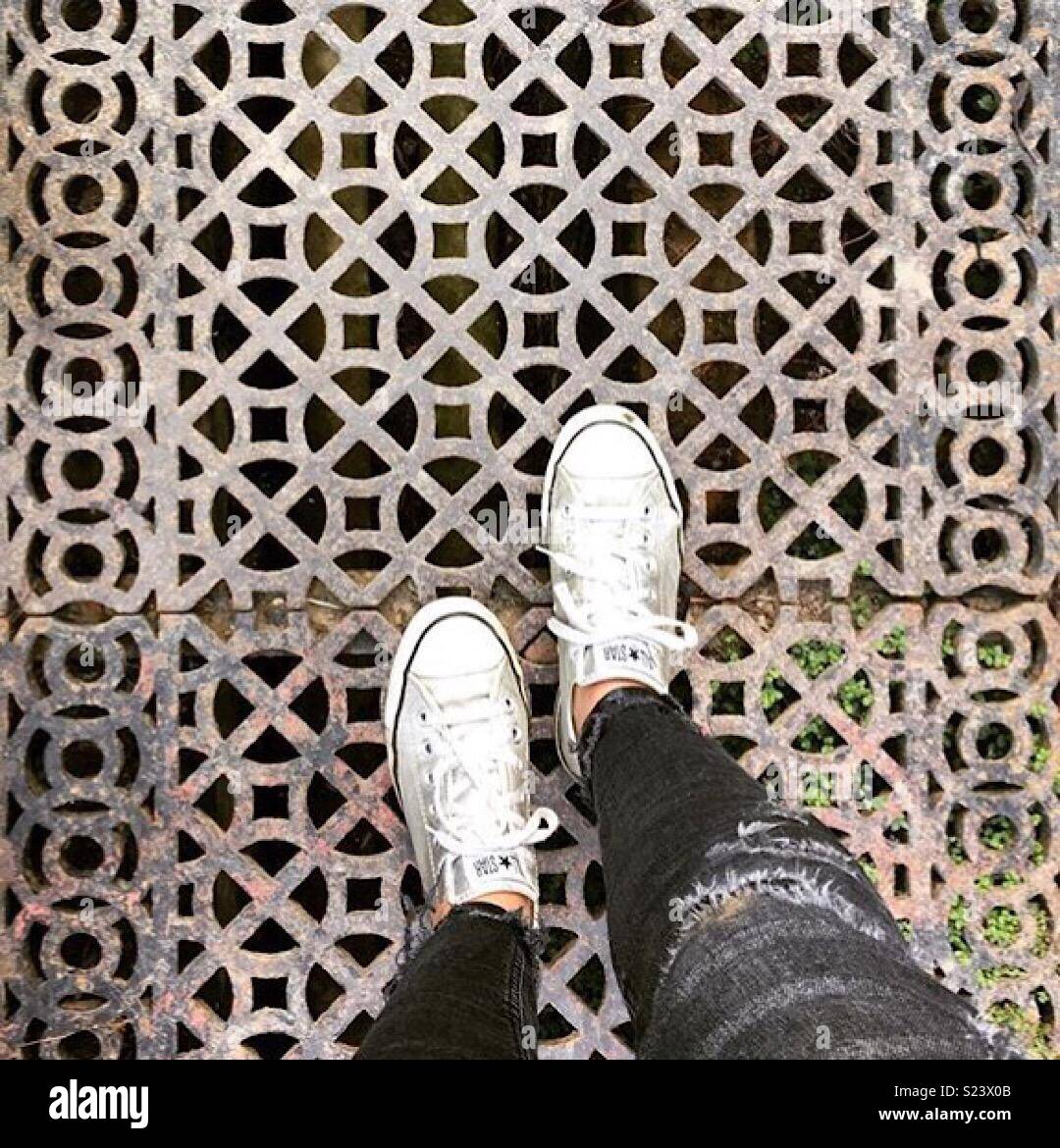 Feet standing on pretty grate Stock Photo