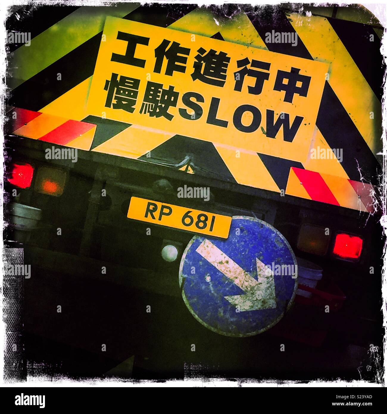 Bilingual 'Slow' sign on a road maintenance truck, Hong Kong - Smartphone Captured Stock Image