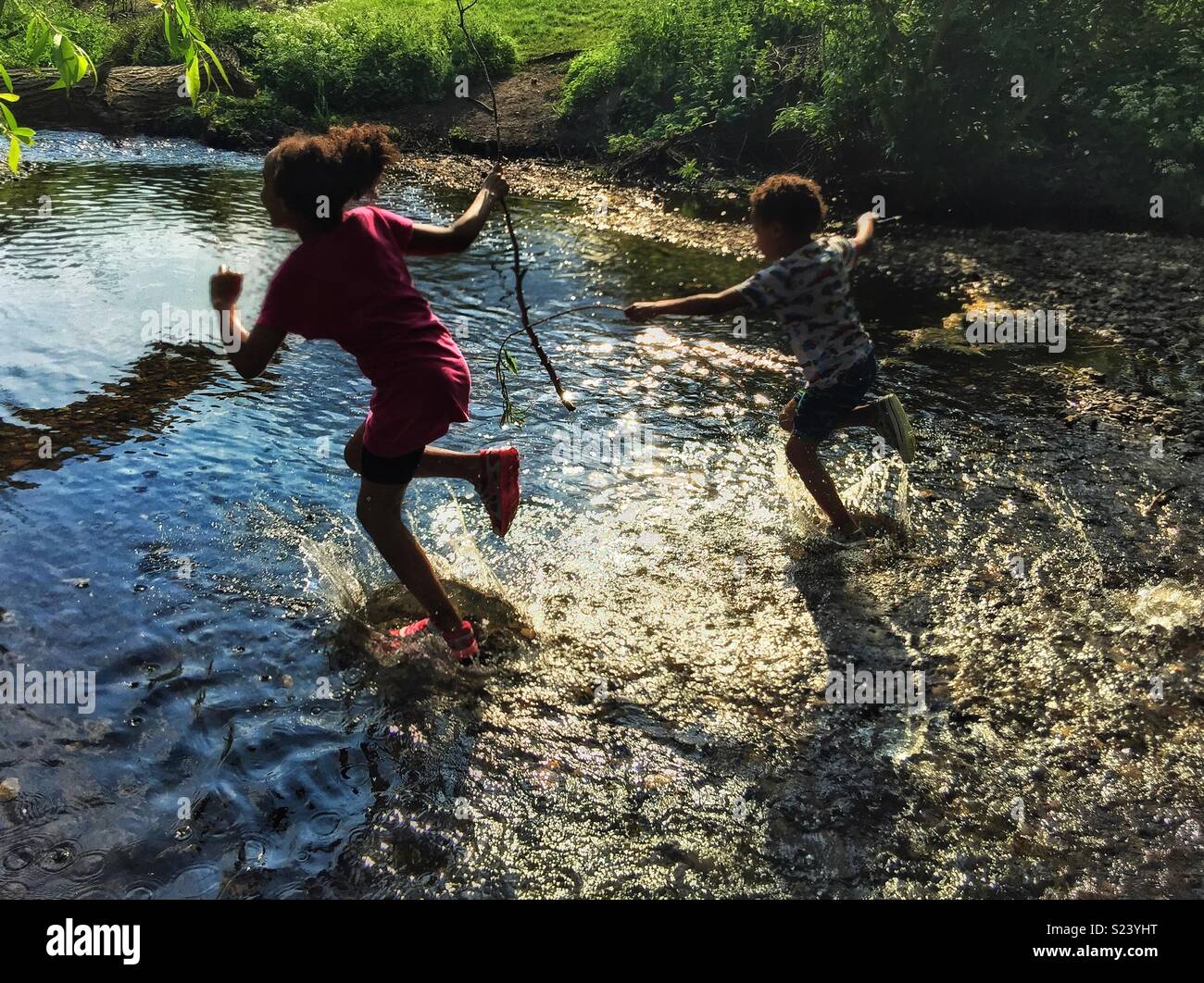 Children running in a stream Stock Photo