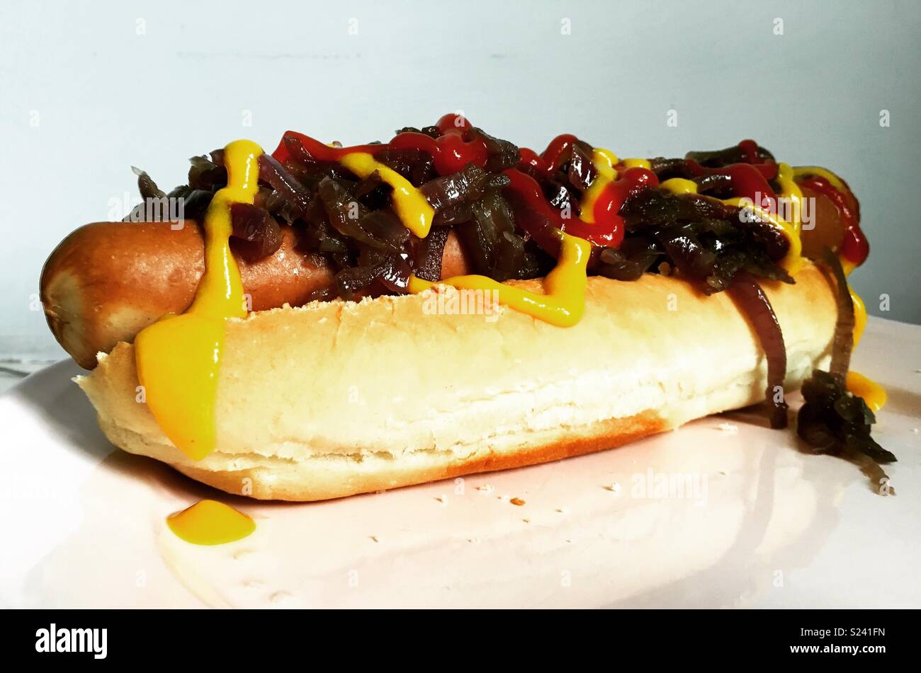 Home cooked hotdog - red onions and all the condiments Stock Photo