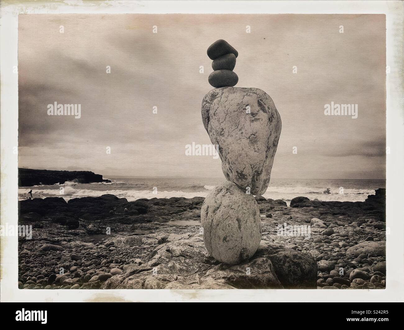 Natural stone/rock balancing sculpture on beach with waves. - Smartphone Captured Stock Image