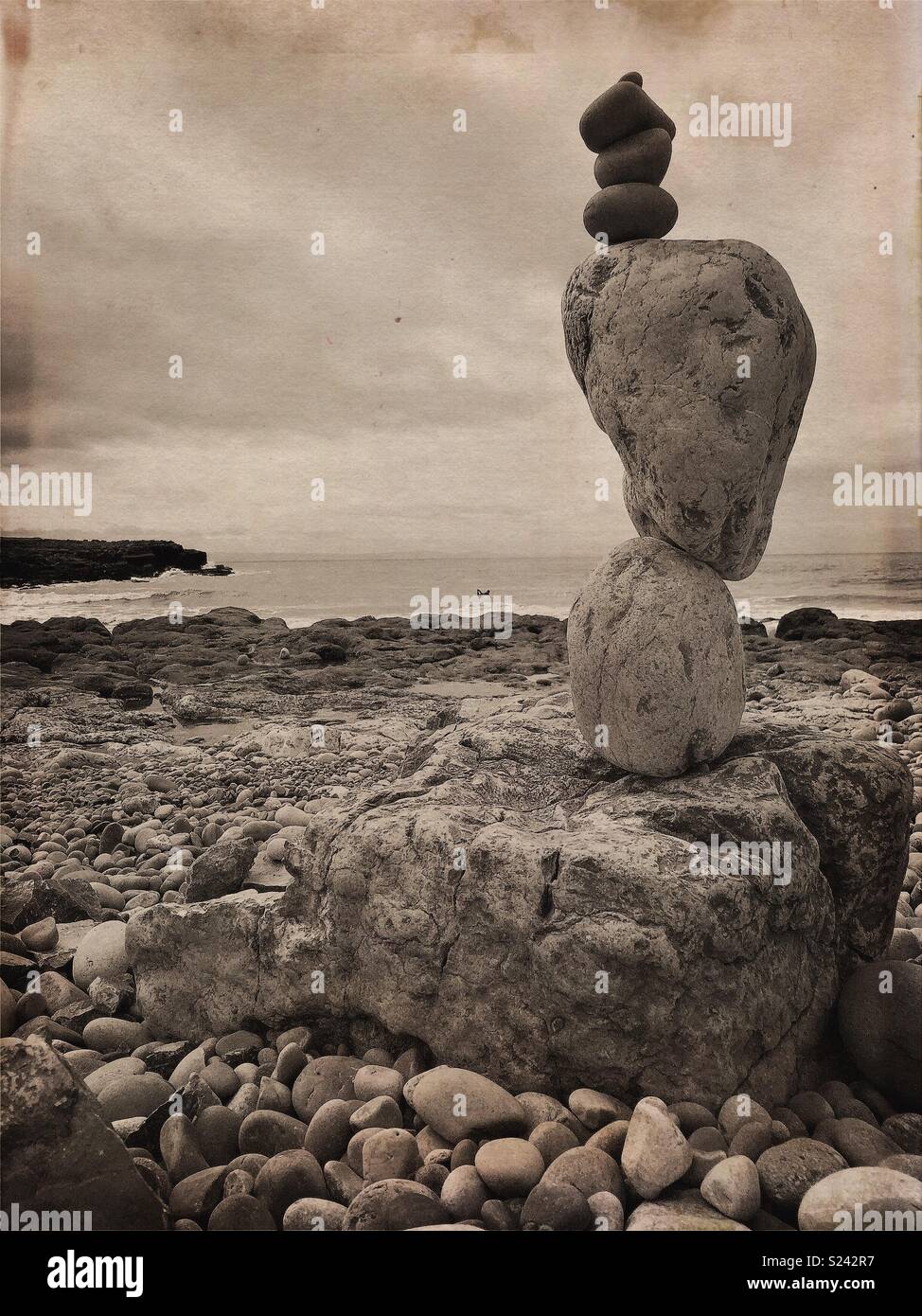 Natural stone/rock balancing sculpture on beach with waves. - Smartphone Captured Stock Image