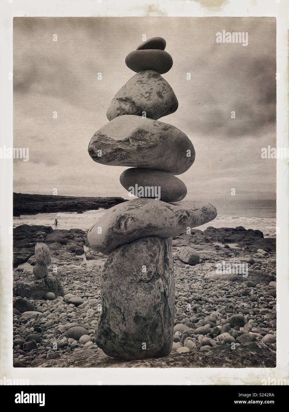 Natural stone/rock balancing sculpture on beach with waves. - Smartphone Captured Stock Image