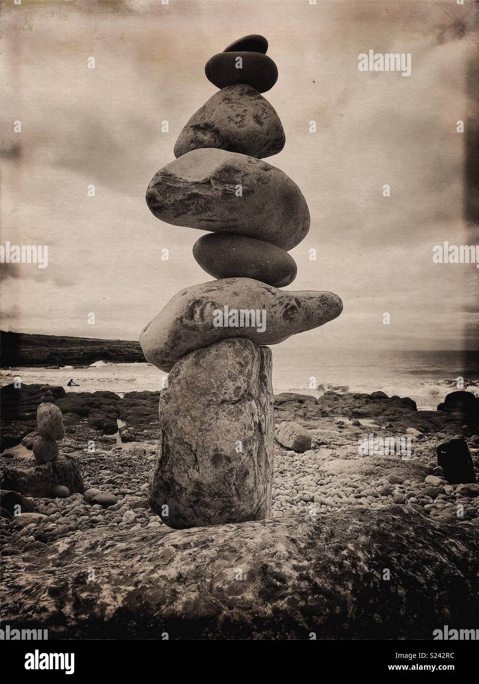 Natural stone/rock balancing sculpture on beach with waves. - Smartphone Captured Stock Image