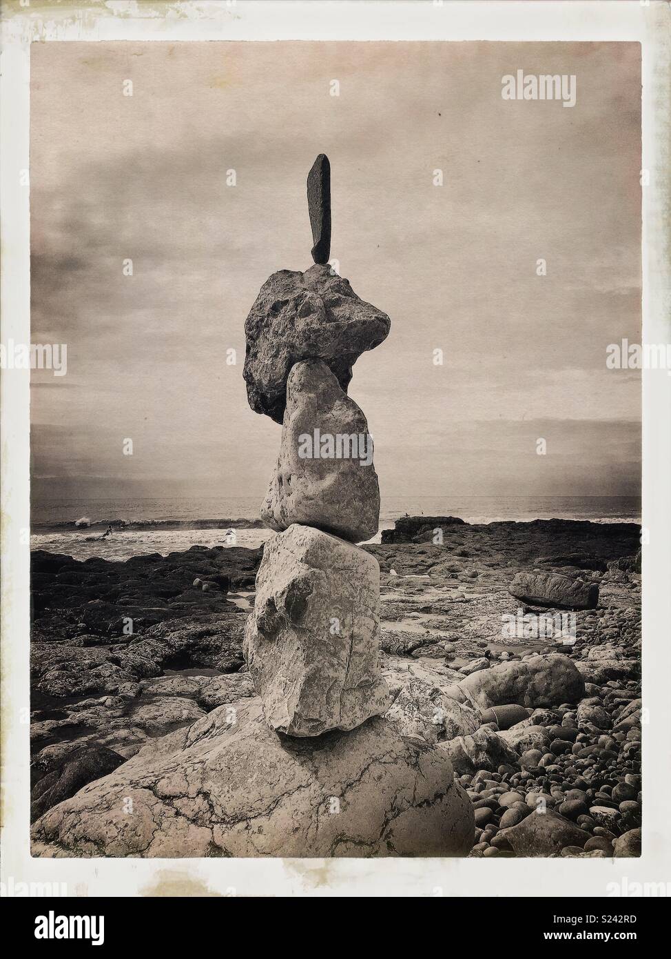 Natural stone/rock balancing sculpture on beach with waves. Stock Photo
