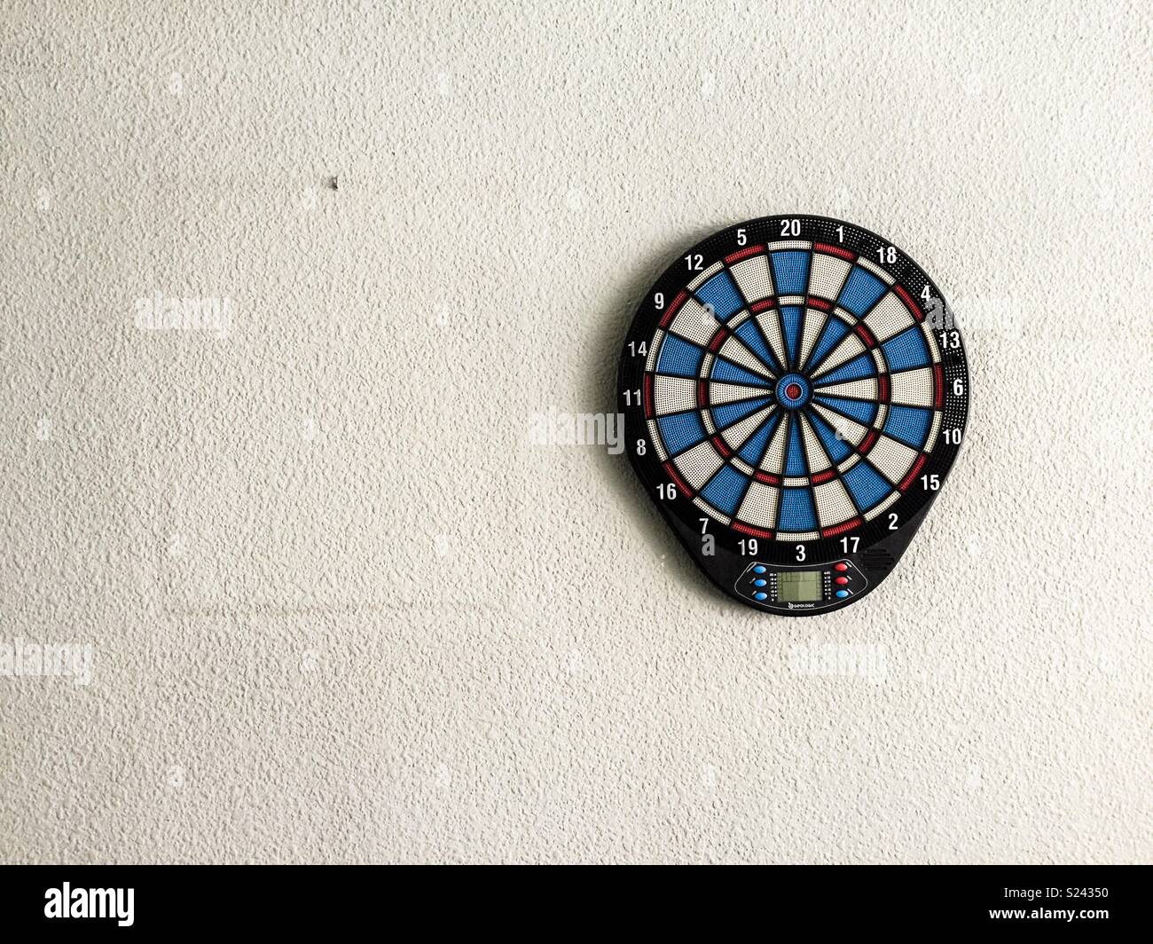 a dartboard hanging on the wall next to the mark of a painting - Smartphone Captured Stock Image