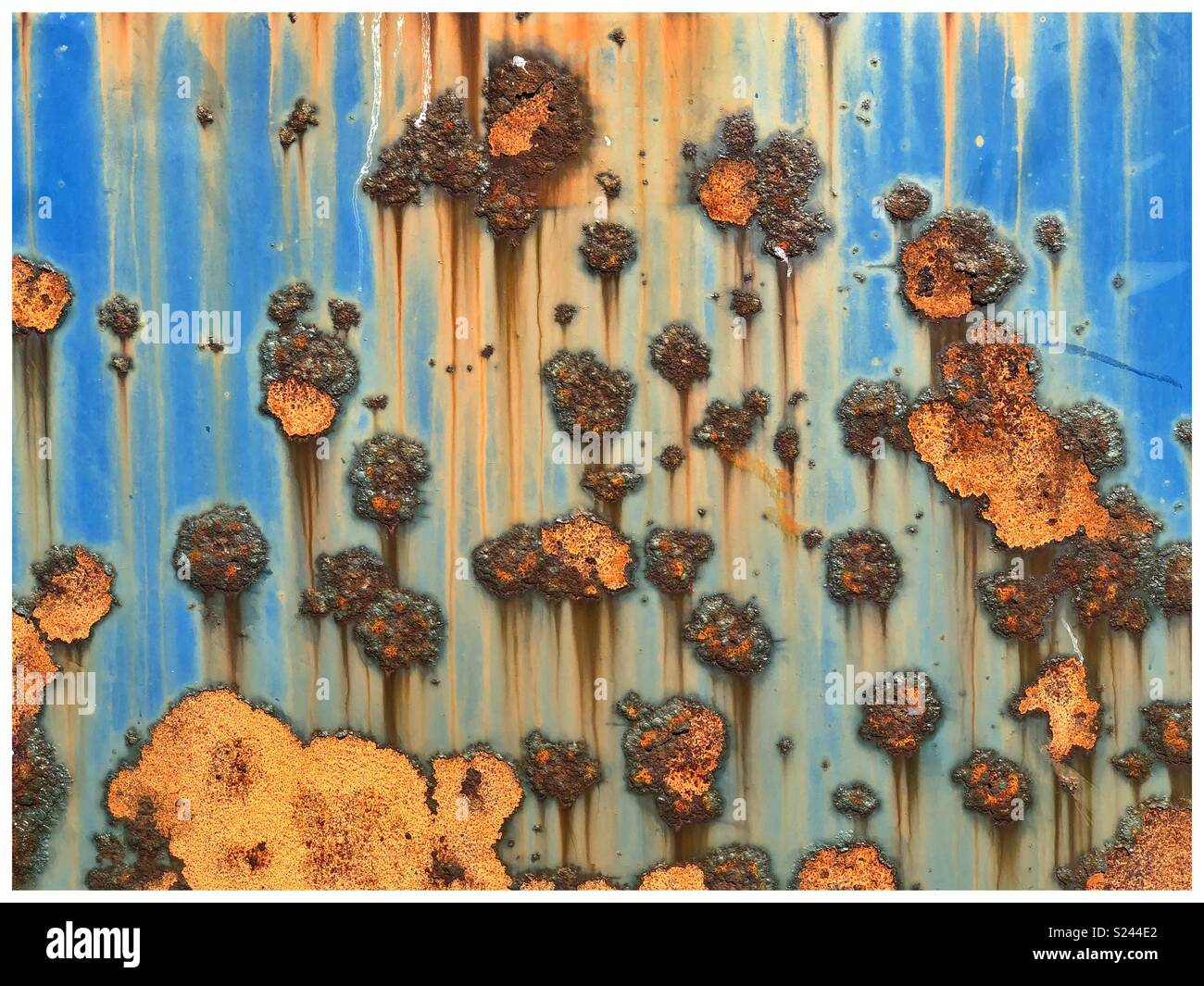 Orange & blue abstract rust patterns on metal. Stock Photo