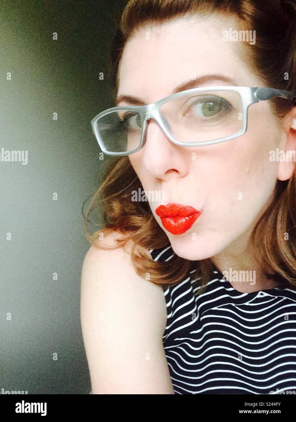 Woman with silver glasses and red puckered lips Stock Photo
