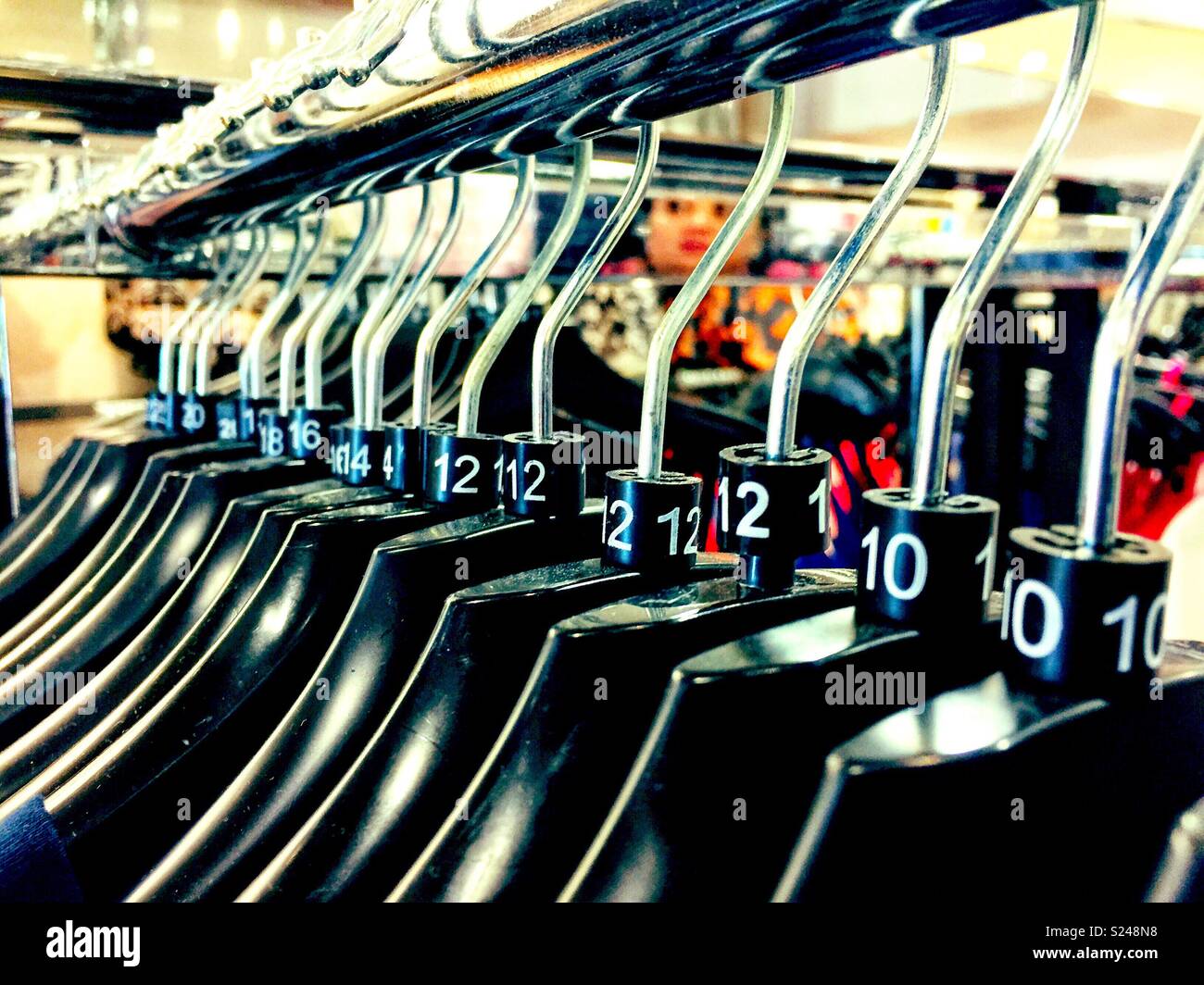 Clothes hangers on a clothes rail in a shop. - Smartphone Captured Stock Image