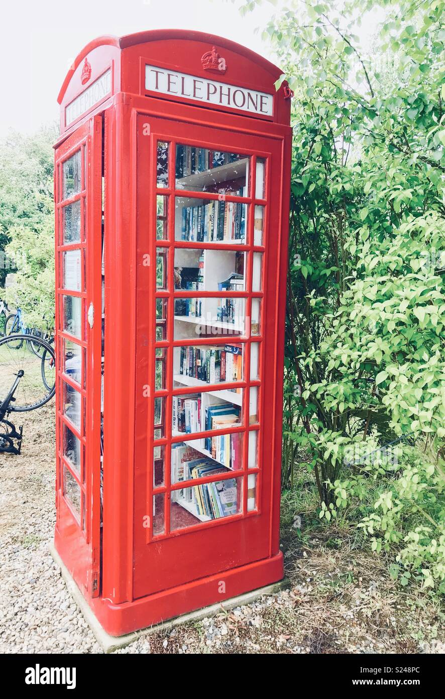 Old BT phone box used as a community library in a small rural Norfolk village Stock Photo