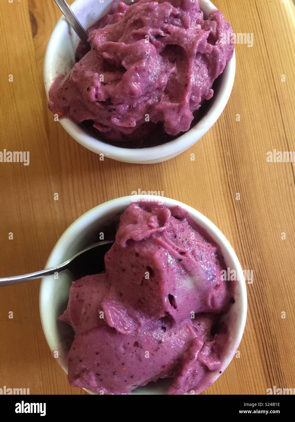 Banana ice cream or ‘nice cream’ with mixed berries served in white ramekins. Stock Photo