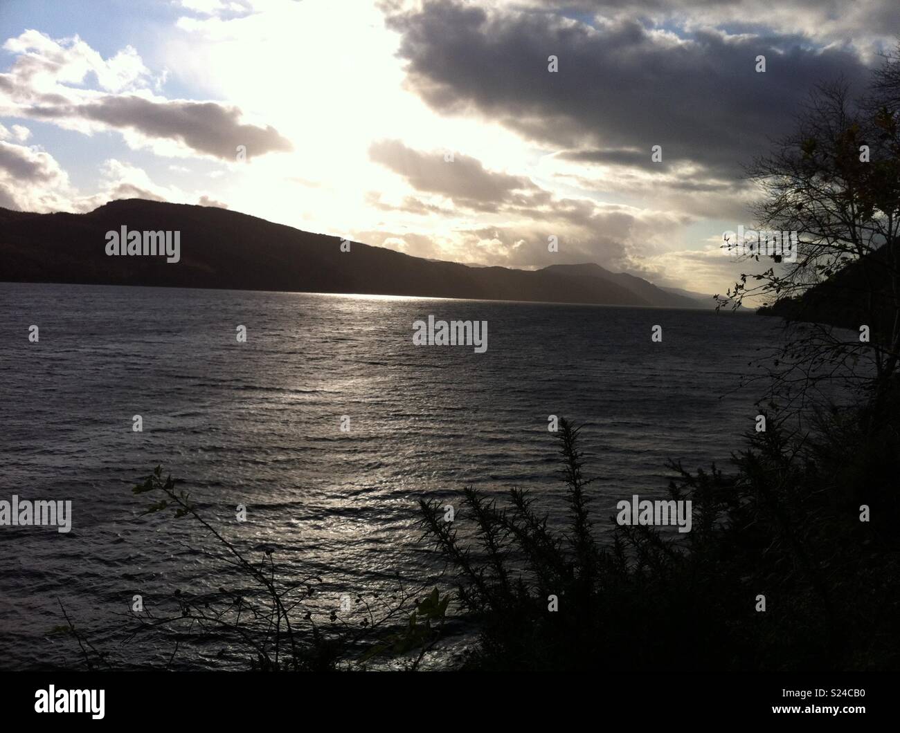Atmospheric picture of Loch Ness, Scotland with Dark Clouds and Bright Sun Stock Photo