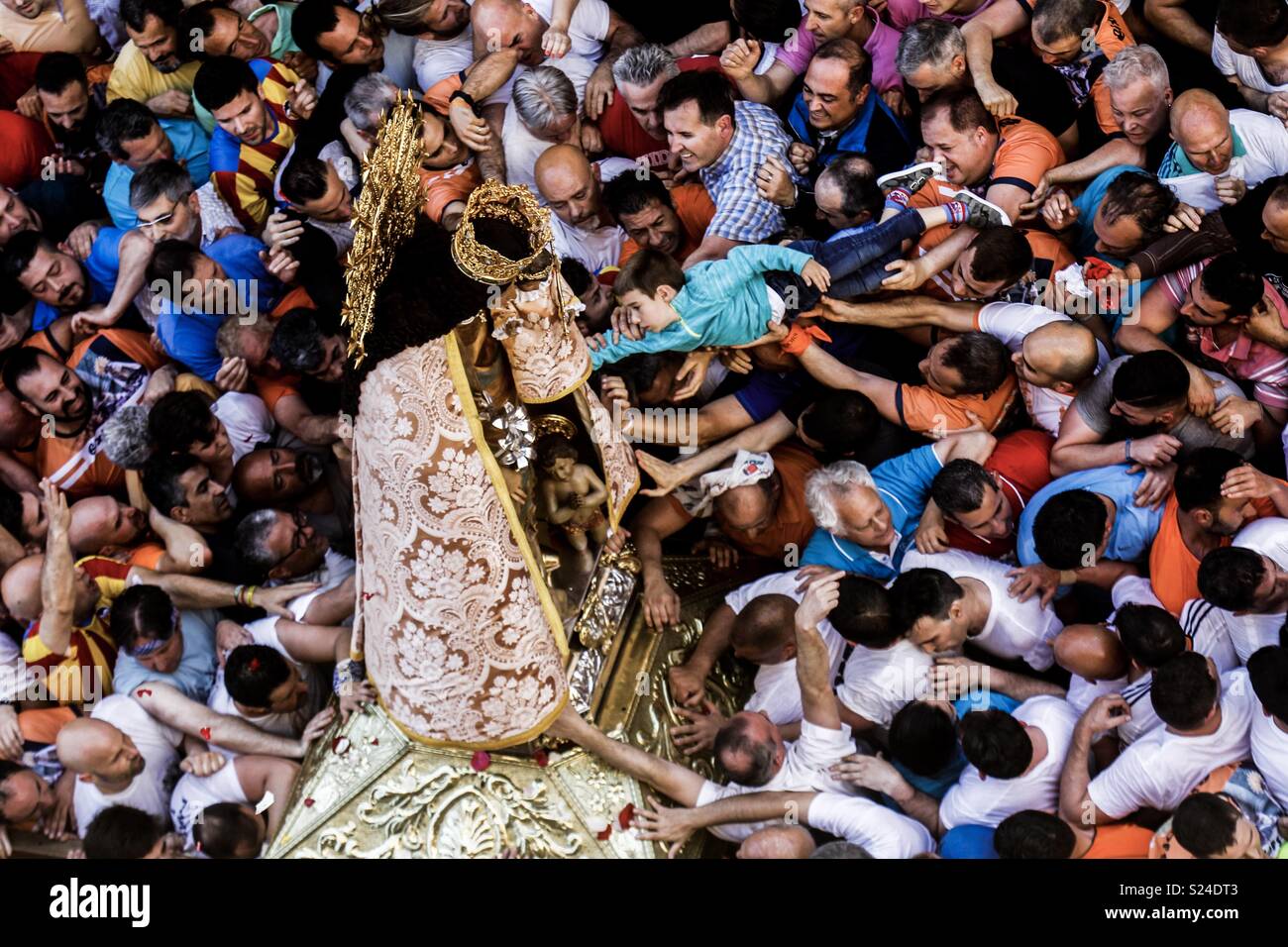 a large group of faithful try to touch the mantle of the Virgin of the helpless during the traditional transfer of the image from the Basilica to the Cathedral of Valencia - Smartphone Captured Stock Image