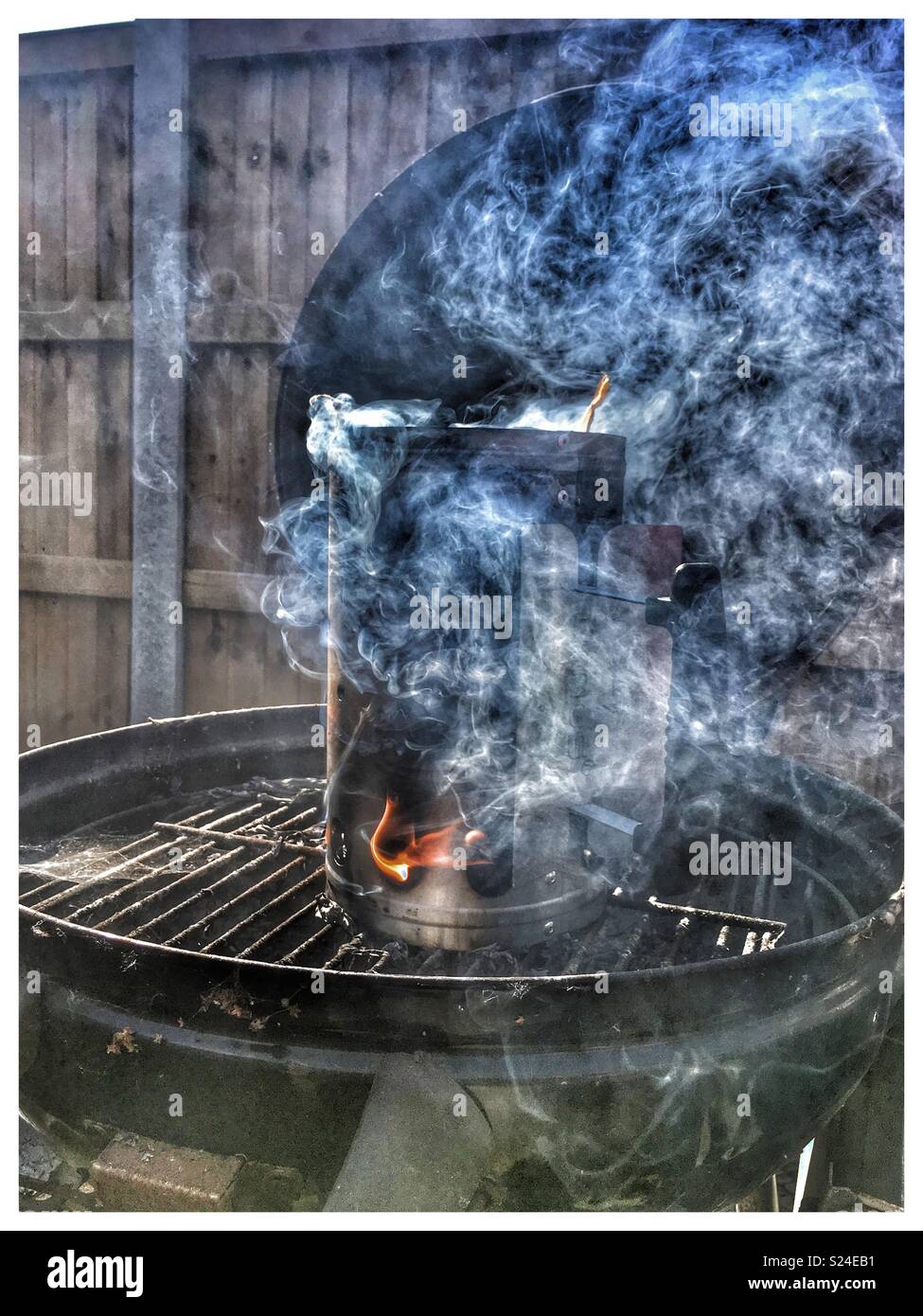 BBQ coals  being fired up in a starter flue. Stock Photo