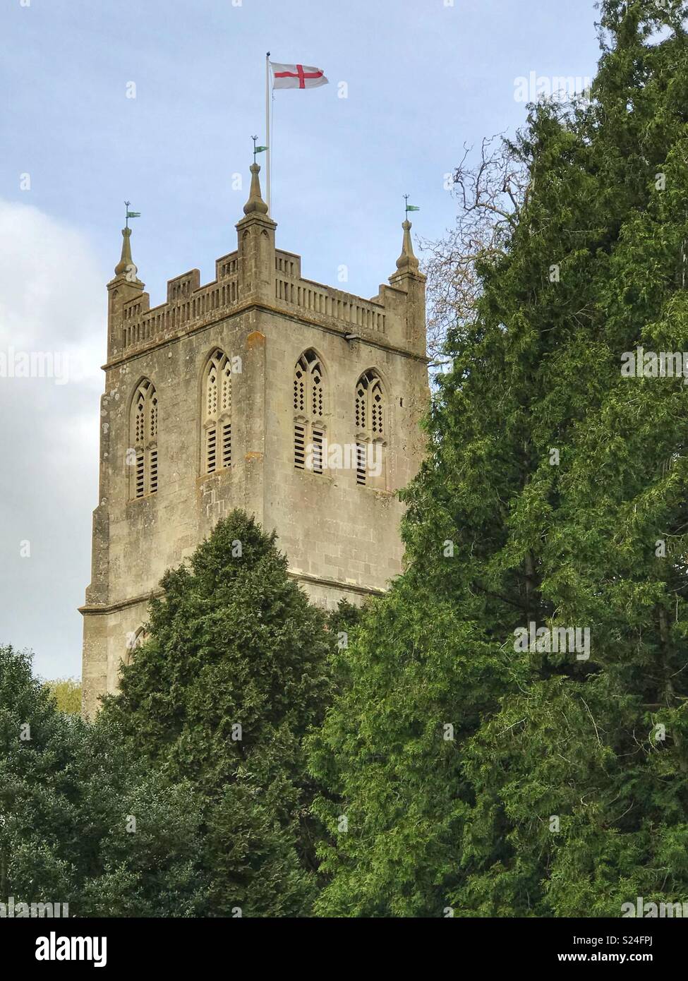 Old church in Berkeley, Gloucestershire, with St. George’s Cross flag flying on St. George’s day. Stock Photo