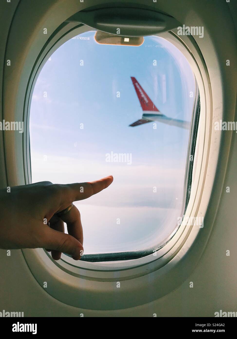 A woman’s finger pointing at Edinburgh as a flight with Norwegian Airlines approaches the city. - Smartphone Captured Stock Image