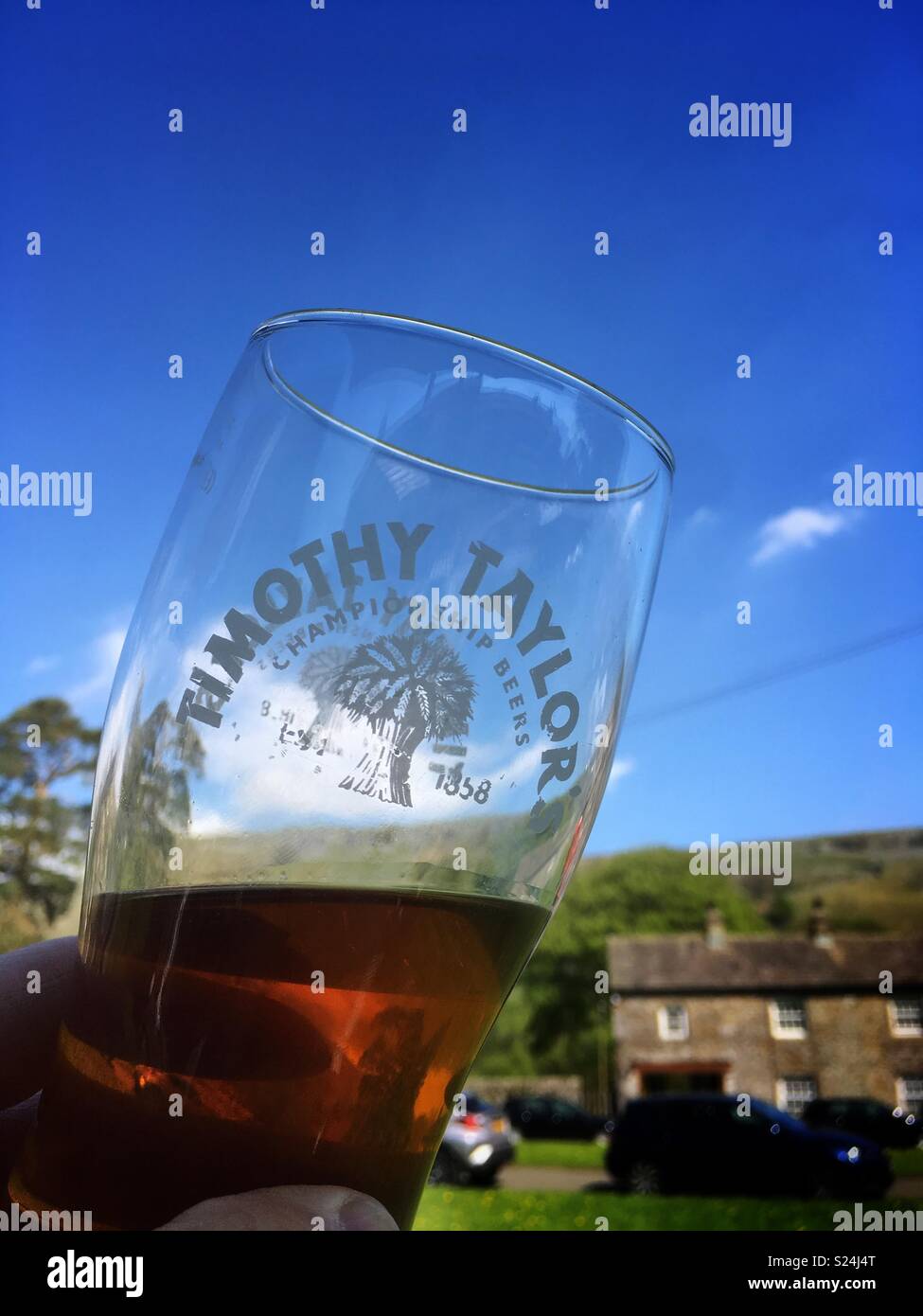Drinking a pint of Timothy Taylor Best Bitter outside a pub in the Yorkshire Dales Stock Photo