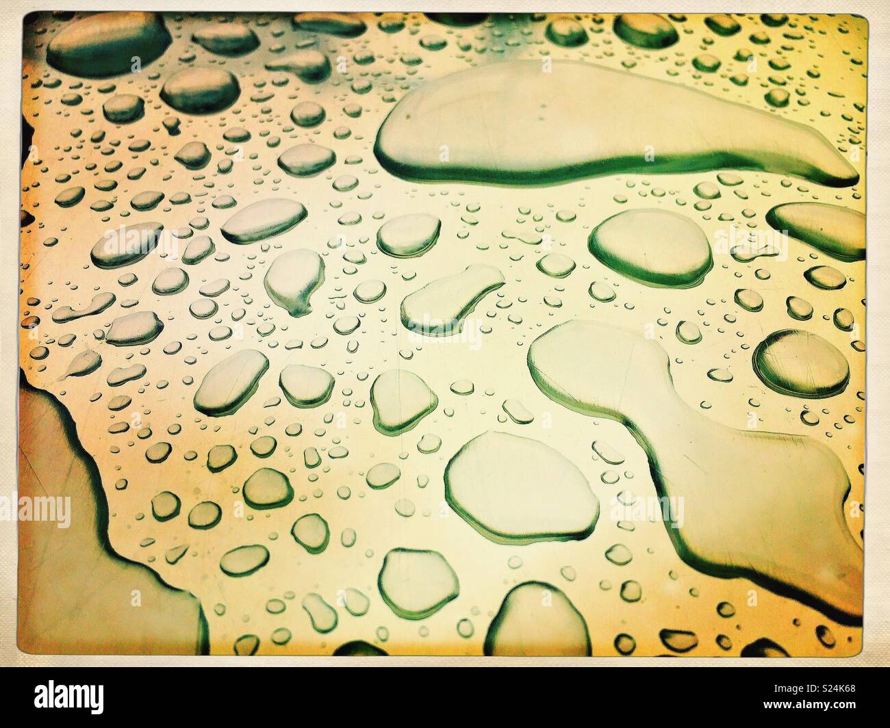 Surface tension of water droplets on metallic surface. Stock Photo